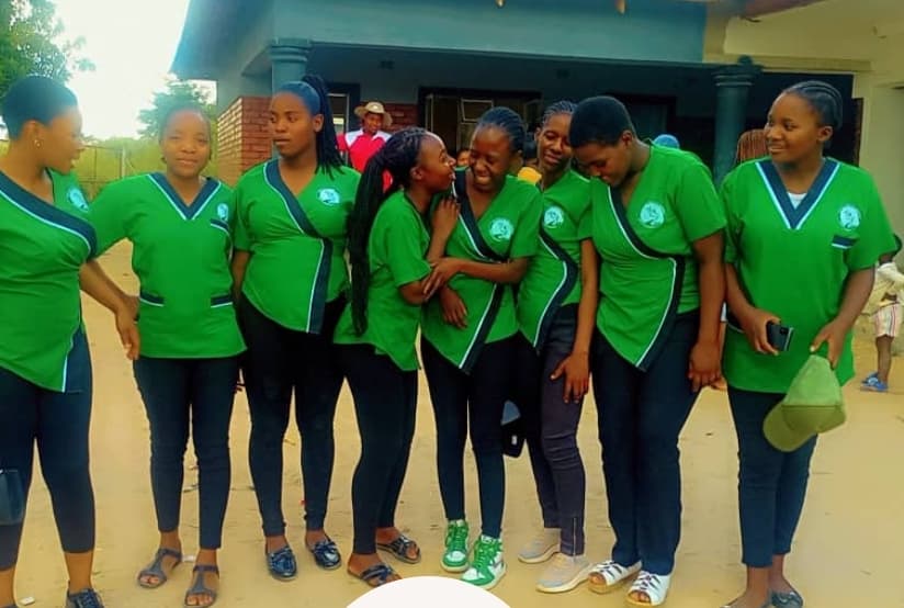 Nurse aide trainees in green uniforms